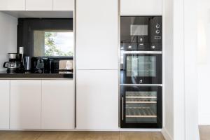 een keuken met witte kasten en een koelkast bij Dalt Son Morro in Santa Margalida