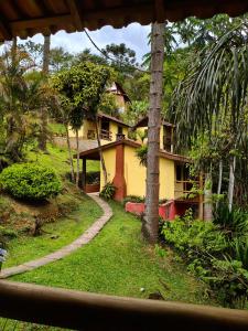 a house in the middle of a forest with a walkway at Pousada Bella Ana in Visconde De Maua