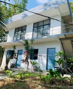 Casa blanca con puertas y ventanas azules en Hidden Well Hiriketiya, en Hiriketiya