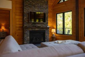 a living room with a fireplace with a tv above it at Lakefront - Spa - Pool table - Mistral 154 in Sainte-Marguerite