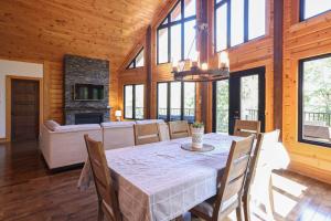 a dining room with a table and a couch at Lakefront - Spa - Pool table - Mistral 154 in Sainte-Marguerite +17 photos