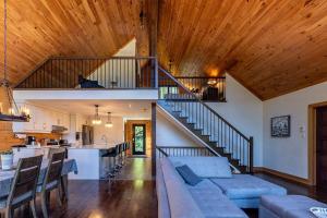 a living room with a couch and a staircase at Lakefront - Spa - Pool table - Mistral 154 in Sainte-Marguerite +26 photos