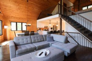 a living room with a couch and a staircase at Lakefront - Spa - Pool table - Mistral 154 in Sainte-Marguerite