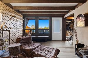 a living room with a couch and a large window at Spa & Nature view - Alpenglow in Sainte-Germaine-du-Lac-Etchemin