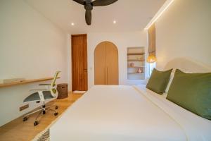 une chambre avec un grand lit blanc et un bureau dans l'établissement Luxury 3BR Seseh Villa Ocean View with Rooftop Lounge & Beach Access, à Cemagi 53 autres photos