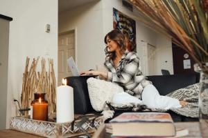 een vrouw die op een bank zit met een laptop bij Corporate Stays Junction 2 Bedrooms in Halifax