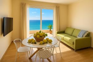 a living room with a table with fruit on it at Blue Wave Apartment in Letojanni