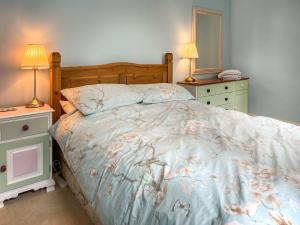 - une chambre avec un lit, 2 tables de nuit et 2 lampes dans l'établissement Bluebell Cottage, à South Brent