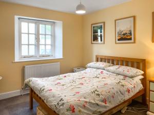 une chambre avec un lit et une fenêtre dans l'établissement Bluebell Cottage, à South Brent