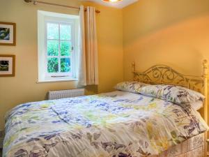 une chambre avec un lit et une fenêtre dans l'établissement Bluebell Cottage, à South Brent