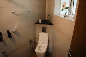 a small bathroom with a toilet and a window at Coastline 4Bedroom cliffside villa in Elattūr