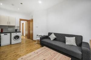 a living room with a couch and a kitchen at Studio 169 in London