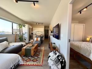 a living room with a couch and a bed at Mossel Bali - Mossel Cove in Mossel Bay