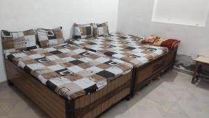 a bed in a room with a checkered blanket on it at Yamuna Kunj Homestay in Govardhan