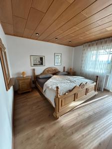 una camera da letto con un letto grande e un soffitto in legno di Ferienwohnung Hocheifelblick a Reifferscheid