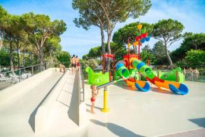 a playground at a park with a slide at Campeggio del Forte in Marina di Bibbona +137 photos