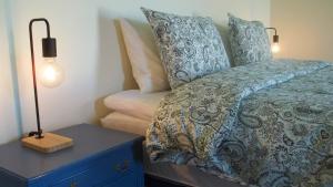 ein Schlafzimmer mit einem Bett und einer Lampe auf einem Nachttisch in der Unterkunft Faial Cottage in Cedros