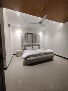 a white bedroom with a bed and a ceiling at Evergreen Lodge - Unmarried couples are not allowed in Rawalpindi +6 photos