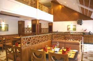 a restaurant with tables and chairs and a bar at Regency Kanchipuram by GRT Hotels in Kanchipuram