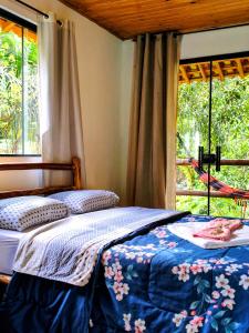 a bedroom with a bed in front of a window at Pousada Bella Ana in Visconde De Maua