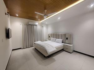 a bedroom with a bed in a white room at Evergreen Lodge - Unmarried couples not allowed in Rawalpindi