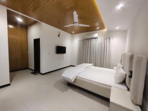 a bedroom with a bed and a ceiling fan at Evergreen Lodge - Unmarried couples are not allowed in Rawalpindi