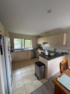 a kitchen with a refrigerator and a counter top at Relaxing 3BR Home by Wattle Downs Reserve in Auckland