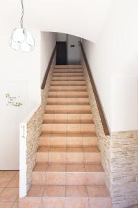 een trap met houten vloeren en een kroonluchter bij Hotel des Etrangers in Bonifacio +3 foto's