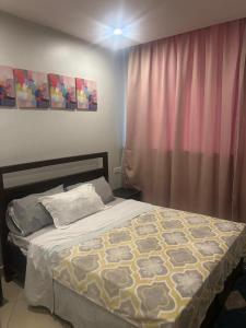 a bedroom with a bed and a pink curtain at Elegant and Modern Homes, 2BR unit in a secure estate near the golf course in Mbarara