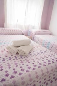 アルムニェーカルにあるCasa Finaのベッドルームにタオル付きのベッド2台が備わります。