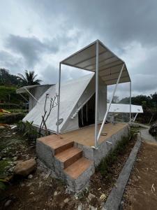 a building with a tent with stairs in front of it at D'River Luxcamp in Cisarua