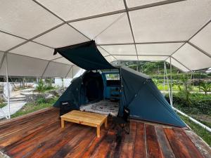 a tent with a table and a bench in it at D'River Luxcamp in Cisarua +17 photos
