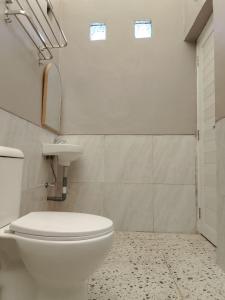 a bathroom with a white toilet and a sink at D'River Luxcamp 