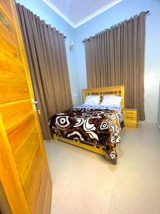 a bedroom with a bed and a window with curtains at Emao Lodge 