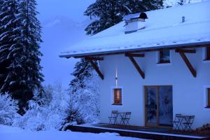 a white house with snow on the roof at B&B Mas de Lagorae in Tesero