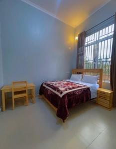 a bedroom with a bed and a table and a window at Emao Lodge 