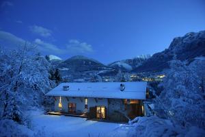 a small house in the snow at night at B&B Mas de Lagorae in Tesero +29 photos