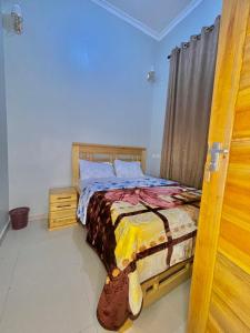 a bedroom with a bed with a wooden head board at Emao Lodge 