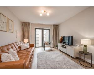 a living room with a couch and a television at Central Belfast Apartments: Citygate in Belfast
