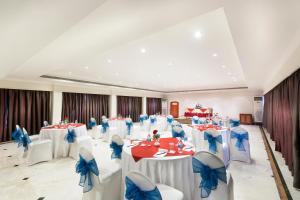 a banquet hall with white tables and blue chairs at Regency Kanchipuram by GRT Hotels in Kanchipuram +28 photos