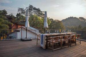 a table with chairs and umbrellas on a deck at Shan Jue Xing She in Nan'an