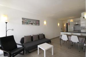 a living room with a couch and chairs and a kitchen at Stupendo Appartamento a Cala’n Bosch Minorca in Cala'n Bosch