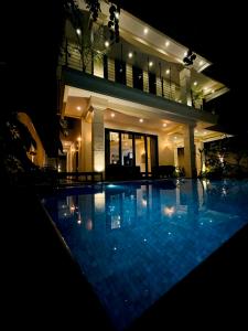 a swimming pool in front of a house at night at The Castle By Scenic Weligama in Weligama