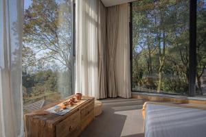a room with a large window with a bed and a table at Shan Jue Xing She in Nan'an +48 photos