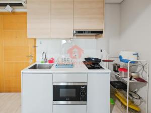une cuisine avec un évier et un micro-ondes dans l'établissement Strategic 2BR Capitol Apt Pool, Gym, Wi-Fi, à Jakarta 28 autres photos