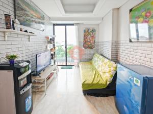 un salon avec un canapé et une télévision dans l'établissement Strategic 2BR Capitol Apt Pool, Gym, Wi-Fi, à Jakarta