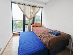 a bedroom with a large bed and a window at Strategic 2BR Capitol Apt Pool, Gym, Wi-Fi in Jakarta +10 photos