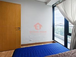 a bedroom with a blue bed and a window at Strategic 2BR Capitol Apt Pool, Gym, Wi-Fi in Jakarta