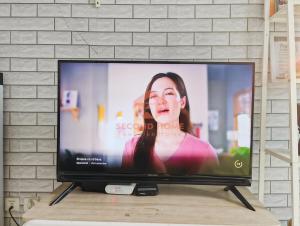 a flat screen tv sitting on top of a table at Strategic 2BR Capitol Apt Pool, Gym, Wi-Fi in Jakarta