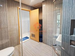 une douche avec une porte vitrée dans une salle de bain dans l'établissement Strategic 2BR Capitol Apt Pool, Gym, Wi-Fi, à Jakarta